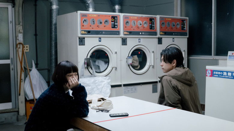 Ayana sitting alone in the glow of the laundromat