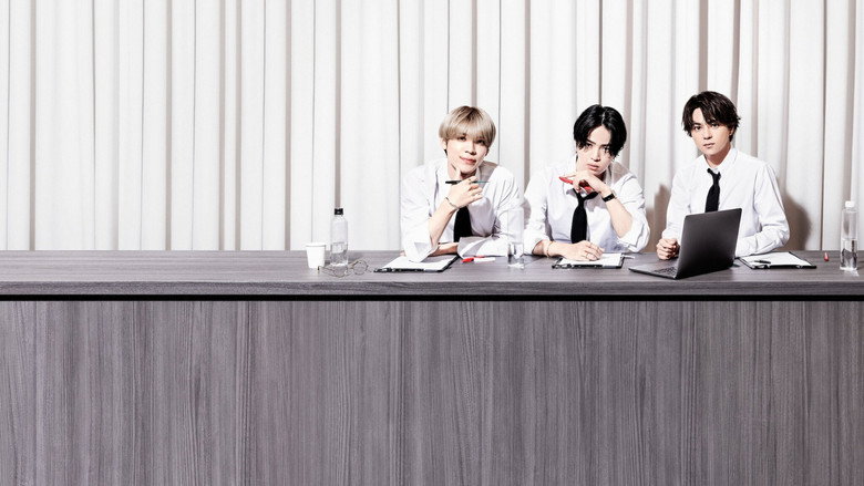 A dimly lit rehearsal room, the trio watching a group of young men perform. The camera lingers on their faces—exhausted, assessing, a little lost.