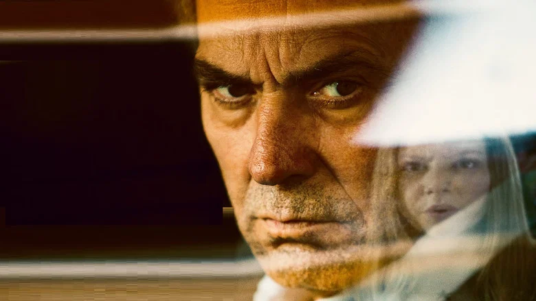 A father sits in a hospital waiting room, his face half-lit by the sterile glow of fluorescent lights, his hands clenched into fists.