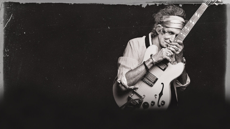Keith Richards seated in a dimly lit room, guitar in hand, surrounded by the warm glow of vintage amplifiers