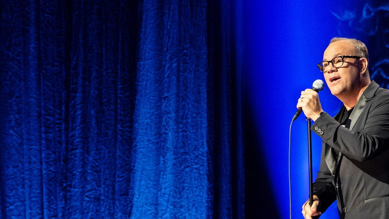 Tom Papa mid-performance, hands gesturing as he delivers a punchline