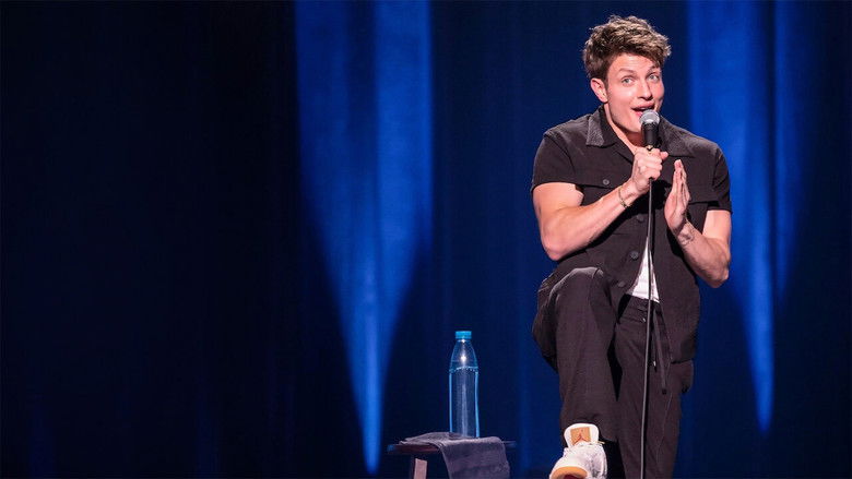 Matt Rife on stage, mid-laugh, arms outstretched as the audience cheers