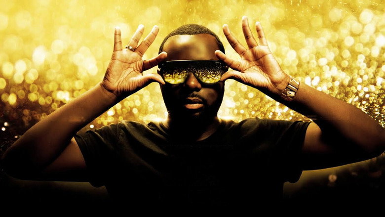 A close-up of Gims on stage, his dark sunglasses reflecting the stadium lights, his mouth open mid-rap, the crowd a blur of energy behind him.