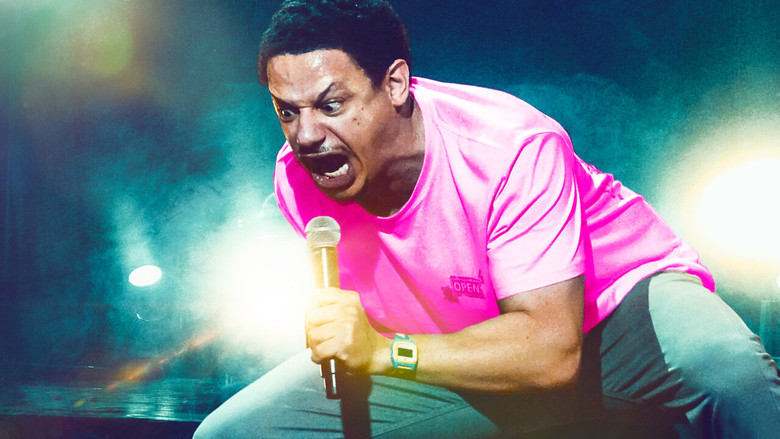 Eric André standing motionless onstage, tie loose, hair wild, the crowd's nervous energy palpable