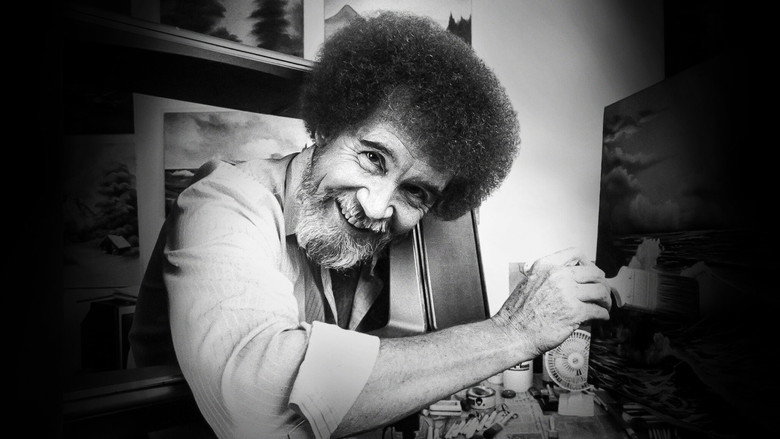 A close-up of Bob Ross's hands painting a tree, his brushstrokes deliberate and calm