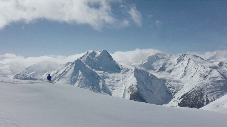Trevor Kennison mid-air in his sit-ski, the Colorado backcountry stretching endlessly behind him