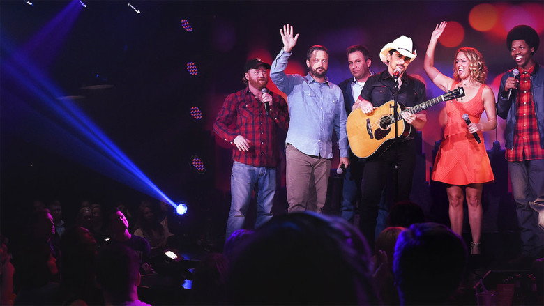 Brad Paisley on stage with a guitar, mid-performance, the audience blurred in the background