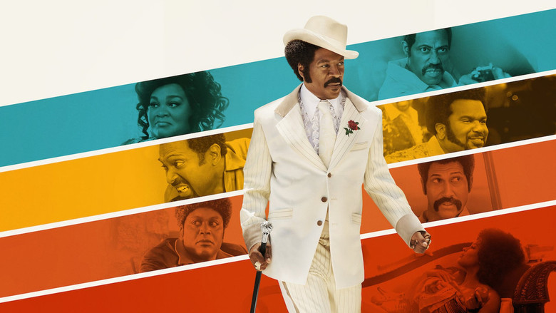 A crowded, neon-lit nightclub where Rudy Ray Moore, dressed in a flashy suit, holds court on stage, his arms outstretched as the audience roars with laughter.