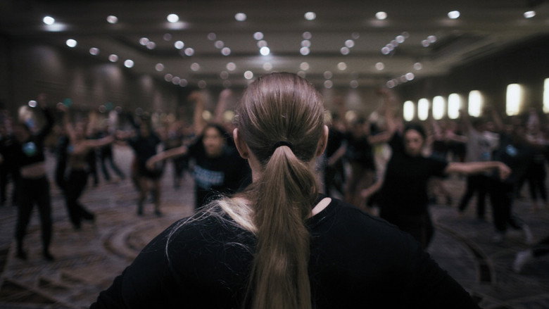 A dancer in mid-motion, limbs blurred against a stark white background, as if caught between stillness and flight.
