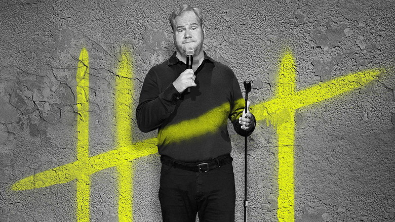 Jim Gaffigan on stage, mid-joke, gesturing with his hands as the audience laughs