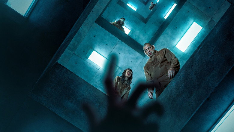 A dimly lit cell in the vertical prison, where inmates huddle around a descending platform laden with food, their faces a mix of desperation and resignation.