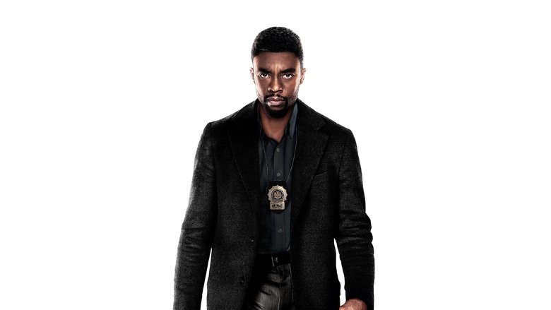 A lone detective stands in the glow of a streetlamp, the Manhattan skyline a jagged silhouette behind him.