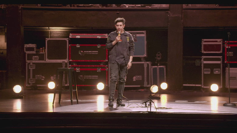 Daniel Sosa on stage, mid-performance, bathed in warm light against a dark background