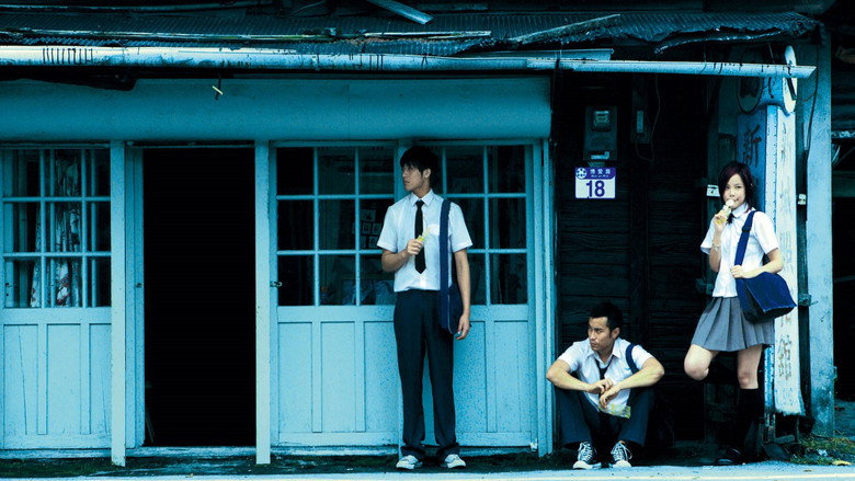 Two boys sit on a rooftop at dusk, their shoulders almost touching, the city sprawling behind them in soft focus.