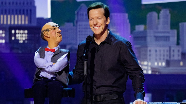 Jeff Dunham onstage with his puppet Peanut, mid-performance, the audience blurred in the background