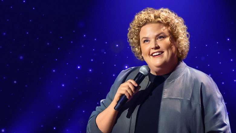 Fortune Feimster on stage, mid-laugh, gesturing with her hands as if telling a story