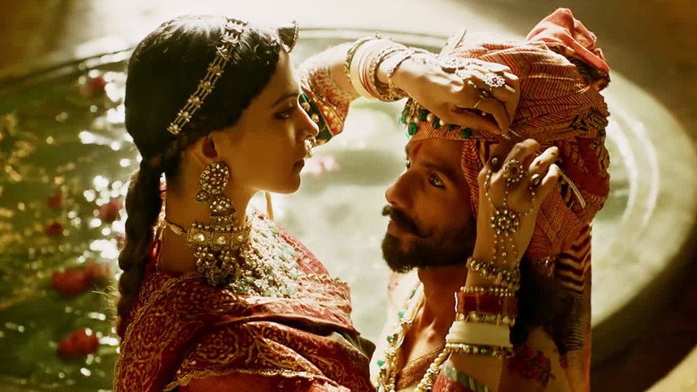 A golden palace courtyard, sunlight filtering through arches, Padmavati standing in the center, her back to the camera, a peacock feather fan casting shadows across her face.