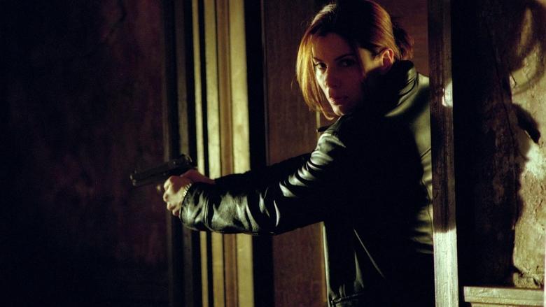 Cassie Mayweather standing in a sterile, dark room while investigating