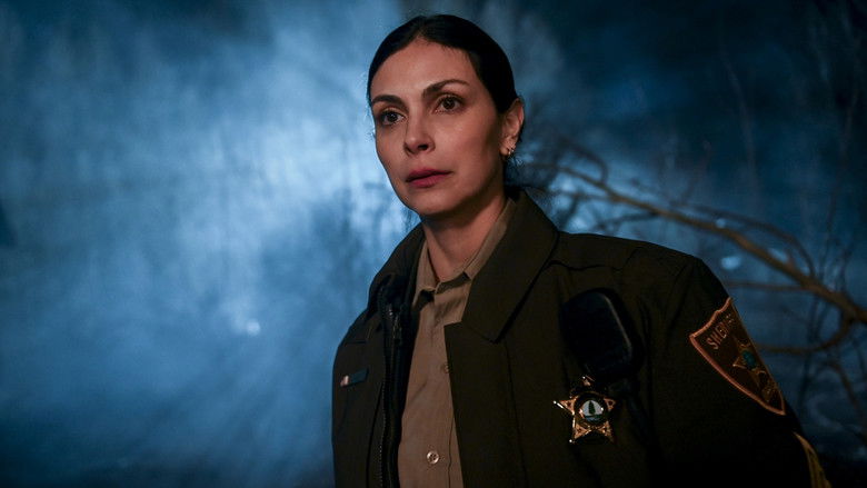 A lonely, two-lane highway stretching out into a desolate, flat landscape under a heavy, overcast sky.