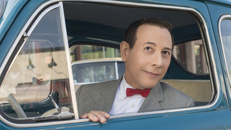 Pee-wee Herman and Joe Manganiello riding in a convertible, the open road stretching behind them, a cartoonish sun beaming down.
