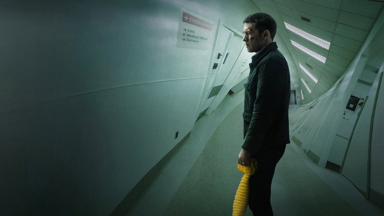Ray Monroe stands in a dimly lit hospital hallway, his reflection distorted in a window.
