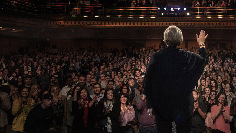 Brené Brown on stage, mid-gesture, her face lit with a mix of warmth and intensity