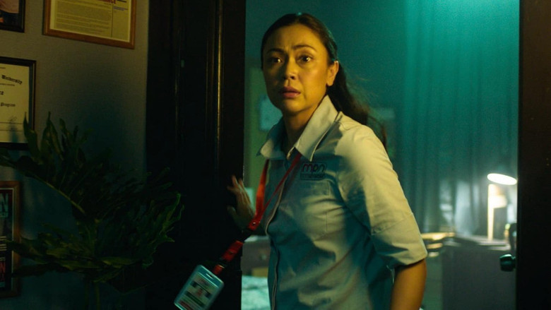 A dimly lit newsroom, the glow of computer screens casting eerie shadows as Vivian Vera (Jodi Sta. Maria) stares at her reflection, her face half-lit by the flickering monitor.