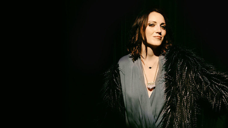 Jen Kirkman onstage, mid-laugh, arms outstretched as if embracing the absurdity of her own premise