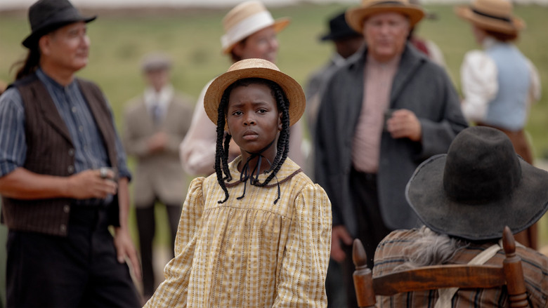 Bert and Sarah reviewing land contracts in the dimly lit cabin