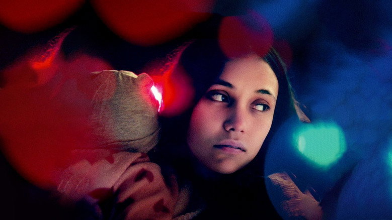 A dimly lit room where Blanca sits across from an interviewer, her face half in shadow, the other half illuminated by a harsh desk lamp.
