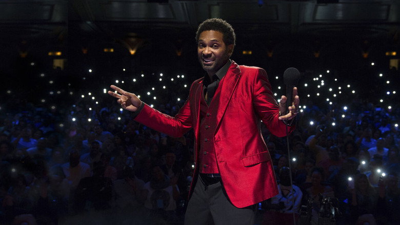 Mike Epps onstage at the Orpheum Theatre, mic in hand, mid-laugh