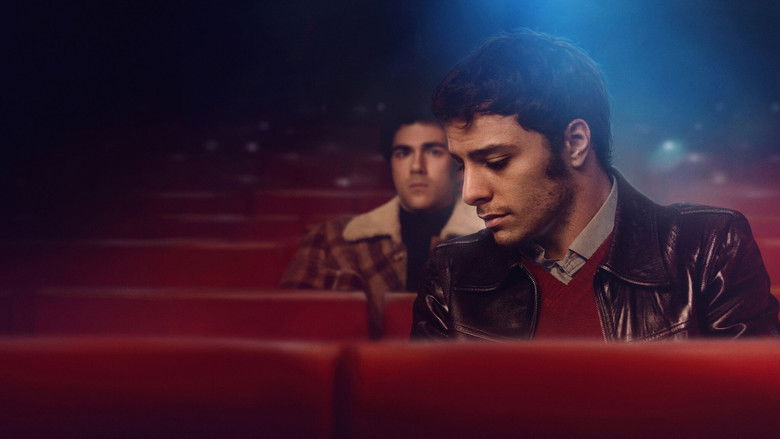 A dimly lit movie theater, the screen glowing with the faces of old film stars, as Enea and Pietro sit in the back row, their shoulders barely touching.