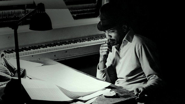 Quincy Jones conducting in a dimly lit studio, his baton raised mid-gesture