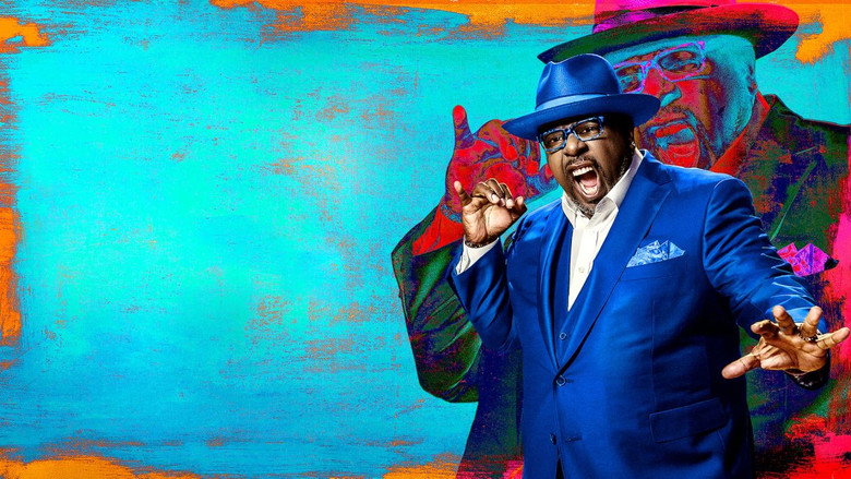 Cedric the Entertainer on stage, bathed in warm light, gesturing to the audience