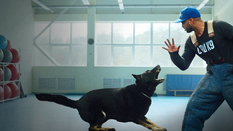 A dog lunges at the camera, teeth bared, while Jas Leverette stands just out of reach, his posture calm but alert