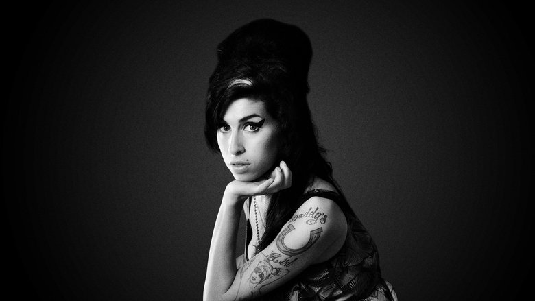 A young Amy Winehouse, eyes closed, singing into a microphone with raw emotion