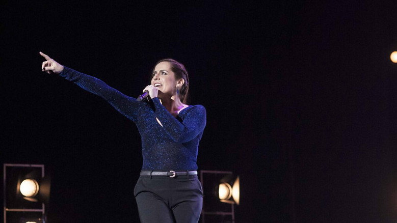 Natalia Valdebenito on stage, mid-joke, her expression a mix of exasperation and mischief