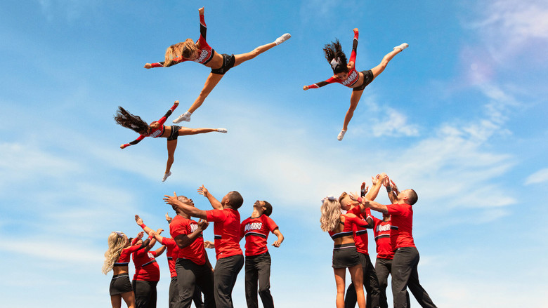 A cheerleader mid-air, limbs splayed in perfect formation, the moment before impact