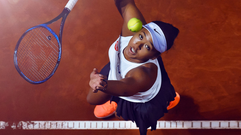 Naomi Osaka mid-swing, her face a mask of concentration, the stadium lights casting long shadows across the court