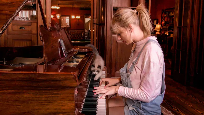 Taylor Swift in a recording studio, bathed in soft light, singing into a microphone