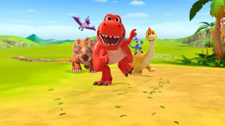A vibrant classroom scene where the four dinosaur friends gather around a table, counting colorful blocks while Rex, the T-Rex, holds up a sign with the number "5."