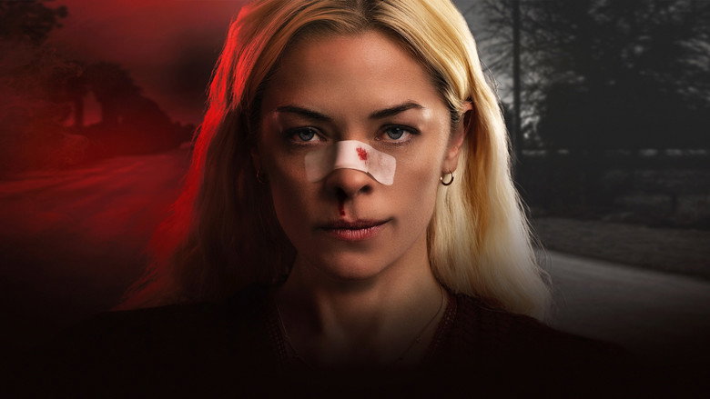 A woman in a blanket, her face bruised, standing on a dark road at night