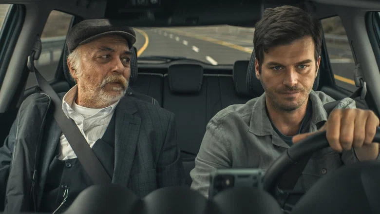 A father and son sit in a car, the father's hands resting on the steering wheel, the son staring out the window at the endless Anatolian landscape.