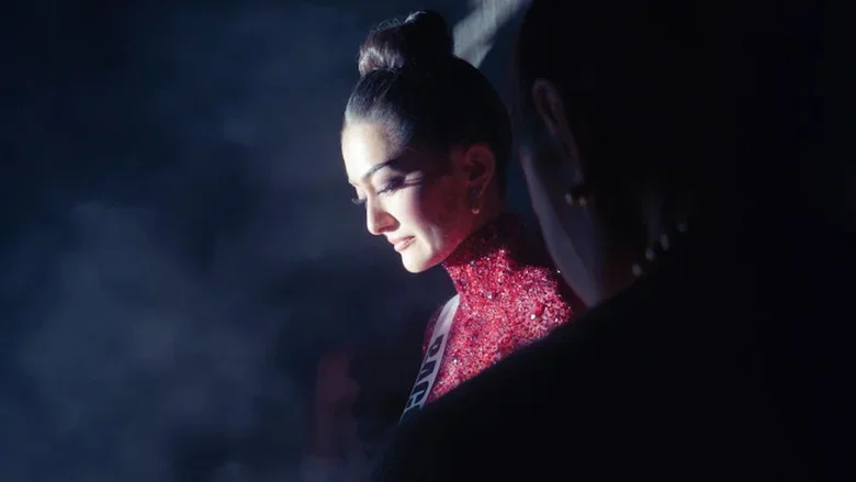 Contestants in a quiet moment, their reflections caught in a mirror as they prepare backstage.