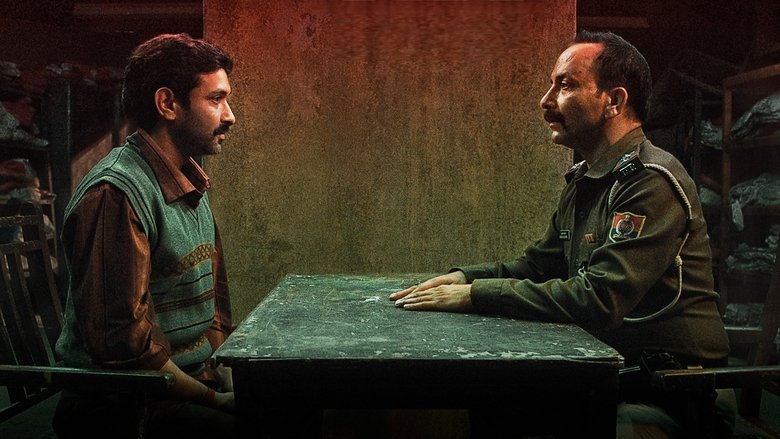 A dimly lit interrogation room, where Vikrant Massey’s Prem Singh leans forward, his face half in shadow, as Deepak Dobriyal’s Inspector Pandey listens with a mix of revulsion and exhaustion.