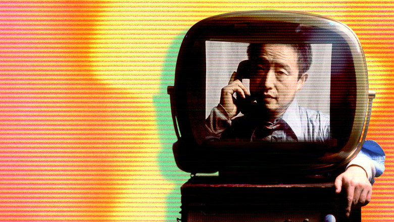 A wall of stacked CRT televisions, each screen displaying a different distorted image of Paik’s face, their glow casting eerie reflections on the surrounding darkness.