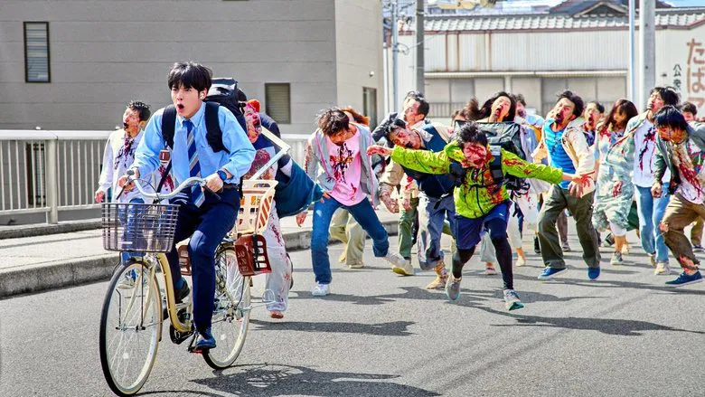 Akira and Shizuka stand in a trashed office, surrounded by overturned desks and flickering fluorescent lights, their faces lit with the giddy exhaustion of people who’ve just realized they’re free.
