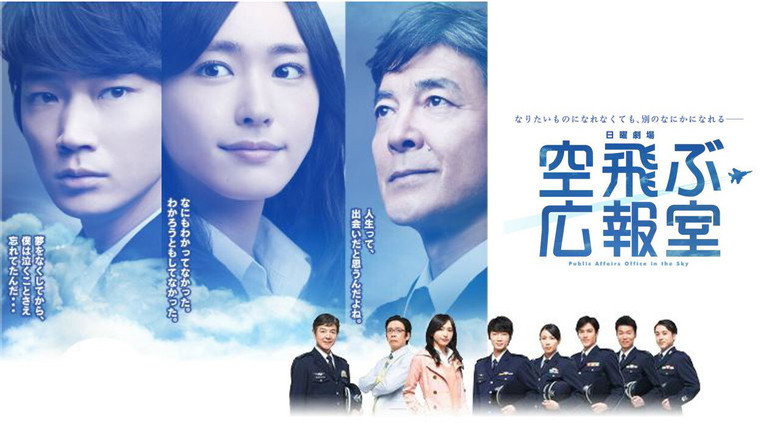 Rika Inaba standing in a television studio, her expression a mix of professionalism and barely contained frustration