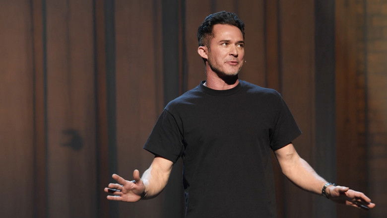 A close-up of Justin Willman mid-performance, his hands gesturing toward a floating object as the audience erupts in laughter