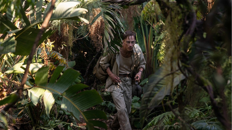 The characters traverse a dense, vibrant jungle landscape, suggesting a shift from urban isolation to a surreal, introspective journey into the unknown.